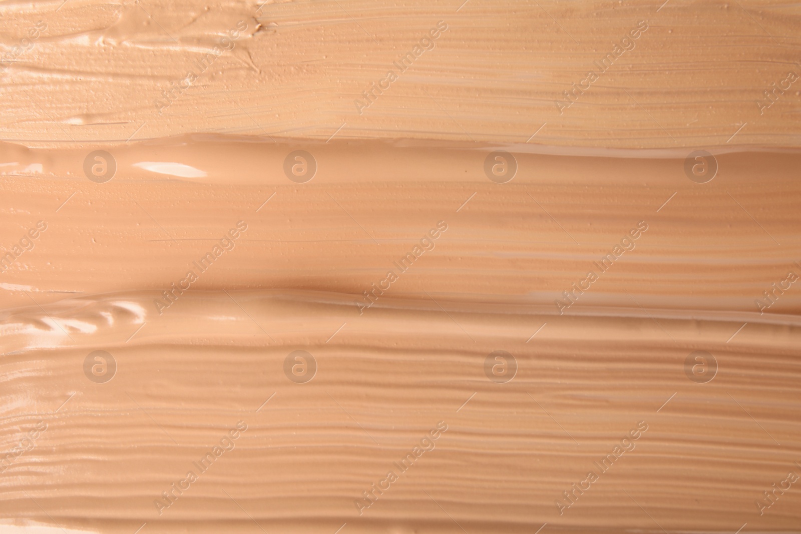 Photo of Samples of different foundation shades as background, top view