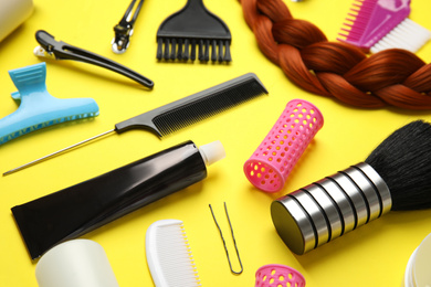 Photo of Professional tools for hair dyeing on yellow background