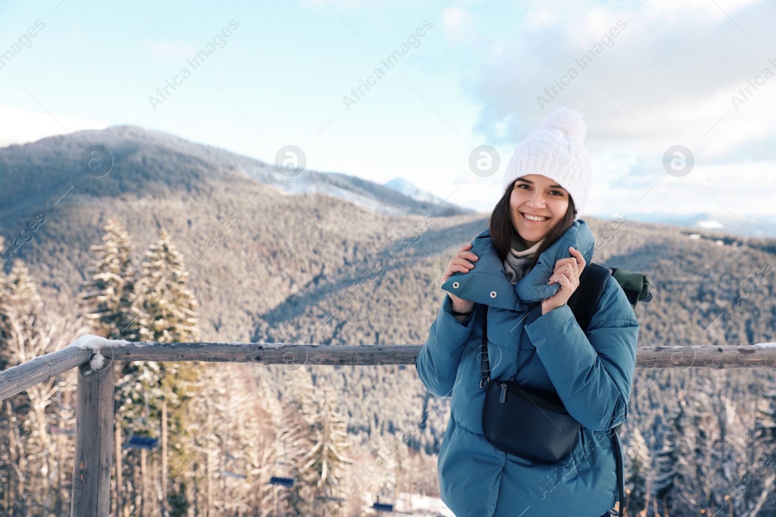 Photo of Happy young woman spending winter vacation in mountains. Space for text