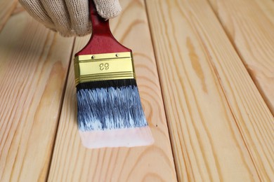Photo of Man varnishing wooden surface with brush, closeup. Space for text