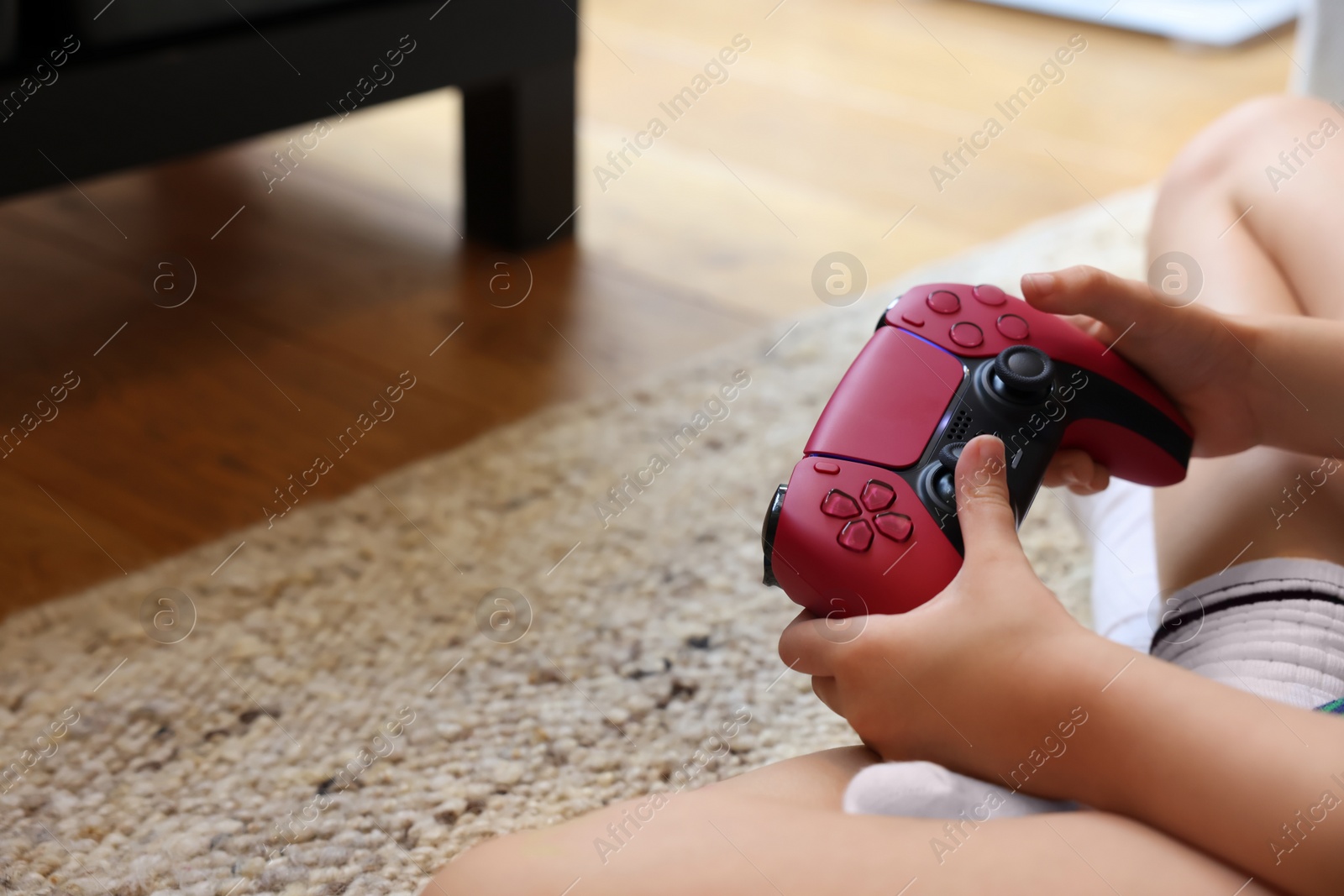 Photo of Child playing video games with controller indoors, closeup. Space for text