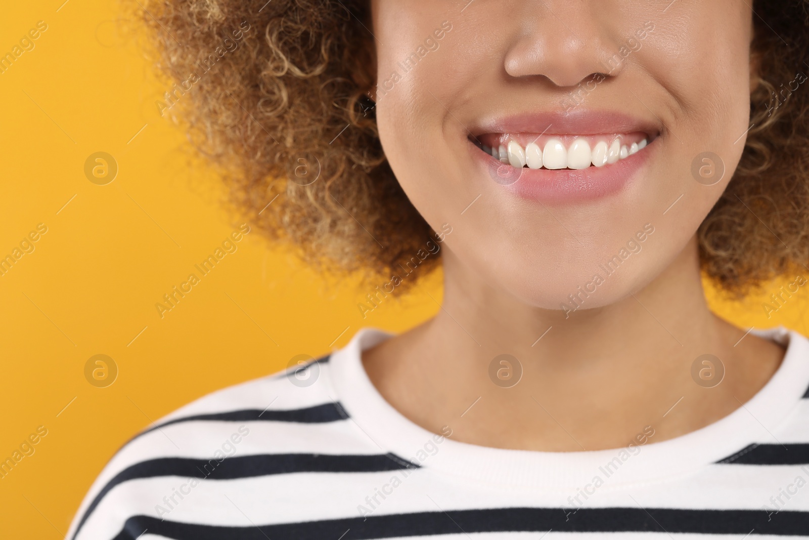 Photo of Woman with clean teeth smiling on yellow background, closeup