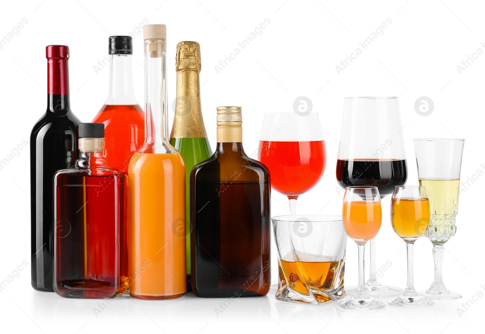 Photo of Bottles and glasses with different alcoholic drinks isolated on white