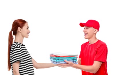 Image of Dry-cleaning delivery. Courier giving folded clothes to woman on white background