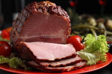 Photo of Plate with delicious ham, lettuce and tomatoes on black wooden table, closeup