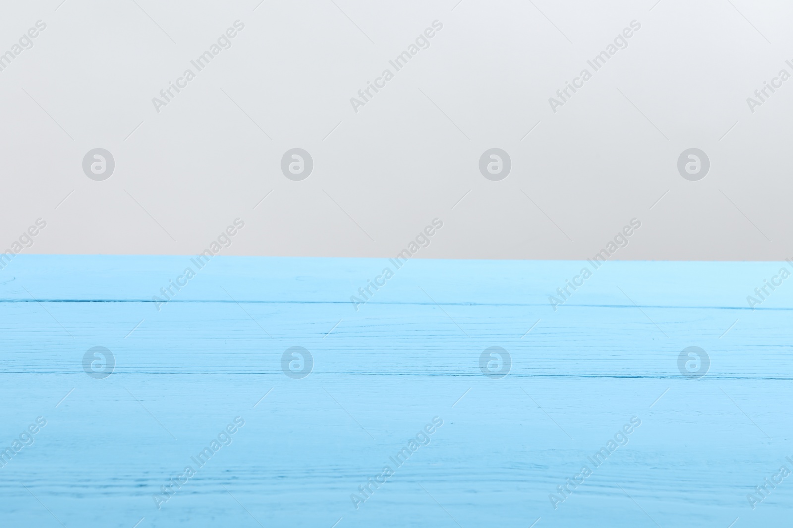 Photo of Empty light blue wooden surface on white background. Space for text