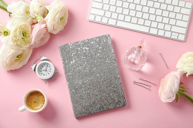 Flat lay composition with glittering notebook, keyboard and spring flowers on color background