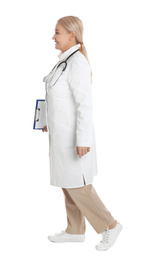 Photo of Mature doctor with clipboard walking on white background