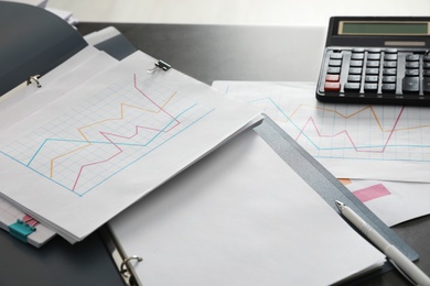 Folders with documents and calculator on office table