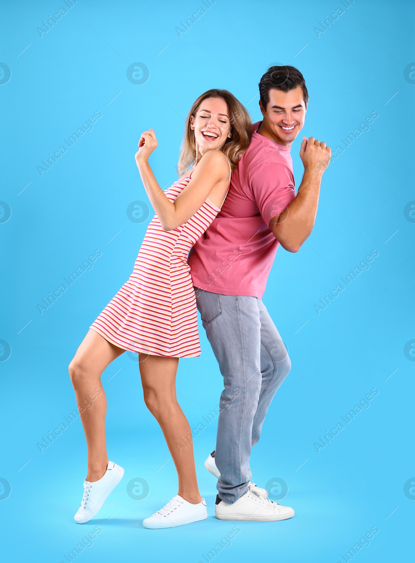 Photo of Beautiful young couple dancing on blue background