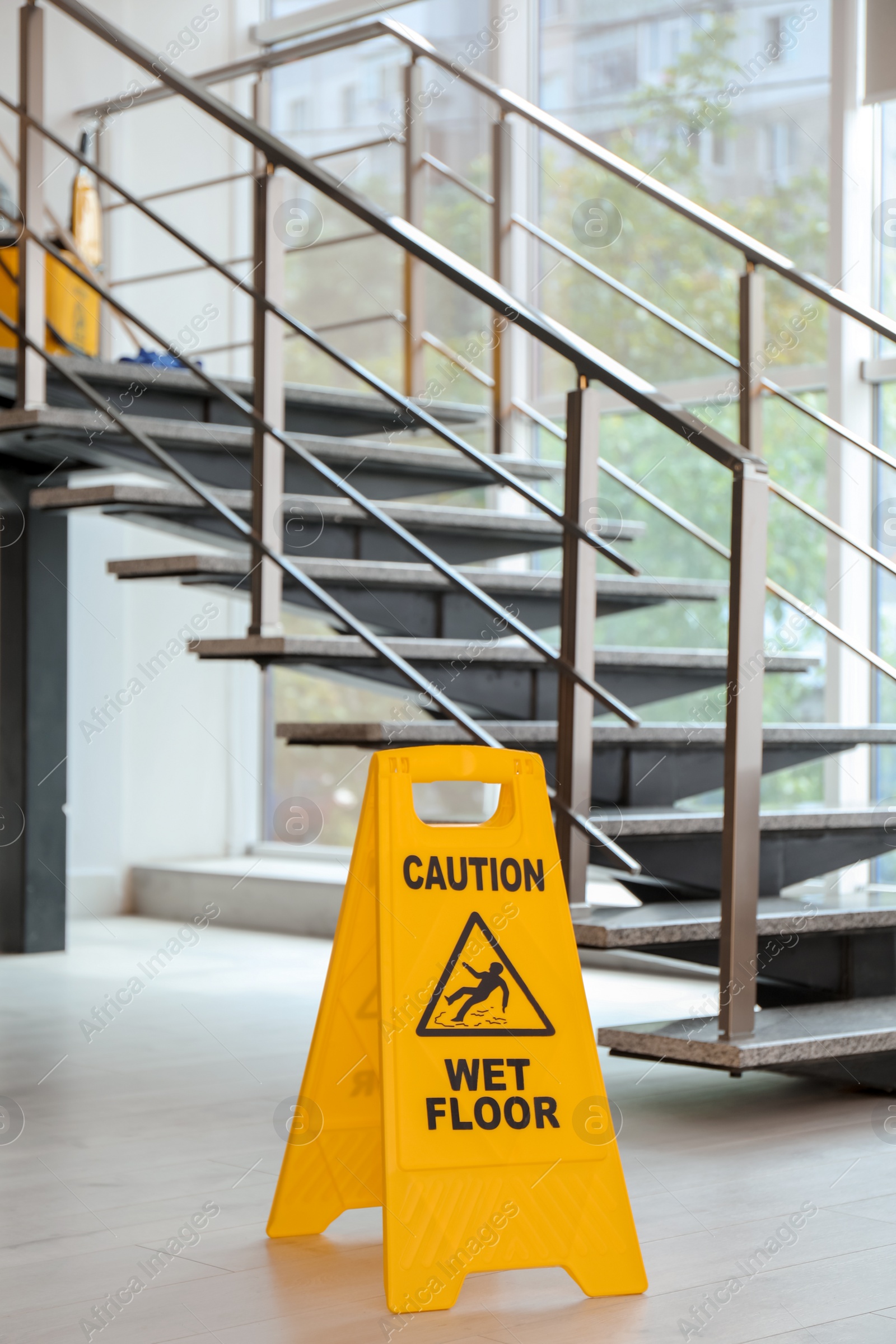 Photo of Safety sign with phrase Caution wet floor near stairs. Cleaning service