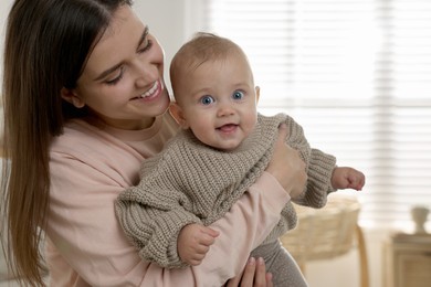 Photo of Happy young mother with her baby at home