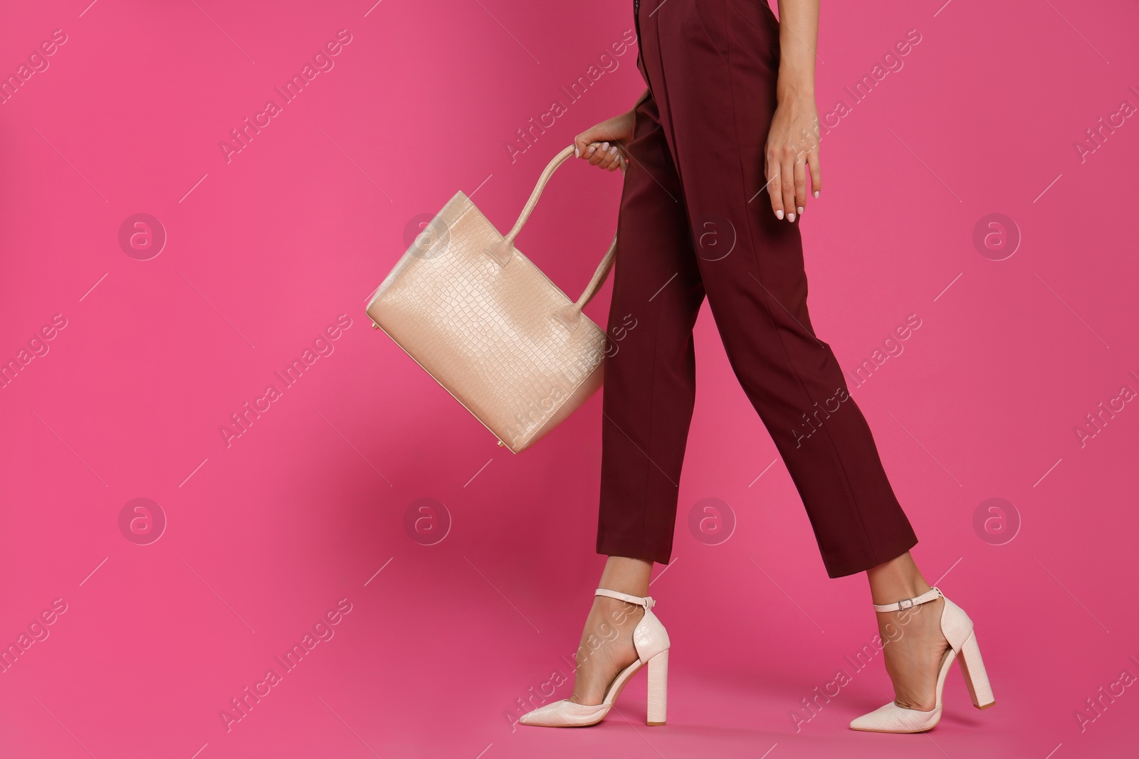 Photo of Woman with stylish bag on pink background, closeup. Space for text