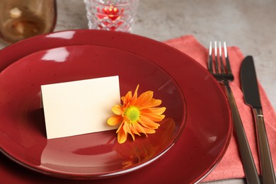 Photo of Beautiful autumn place setting with blank card and decor on grey table, closeup