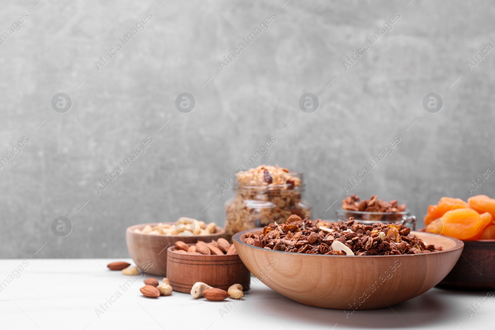 Photo of Tasty granola with nuts and dry fruits on white table. Space for text