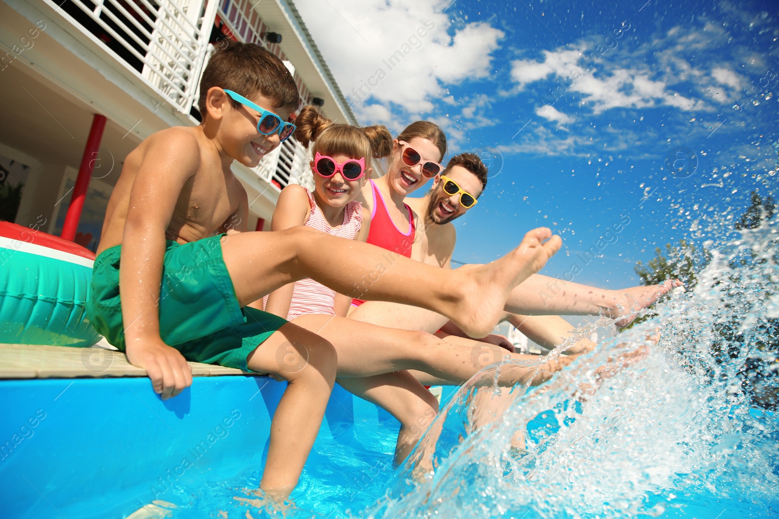 Photo of Happy family splashing water in swimming pool