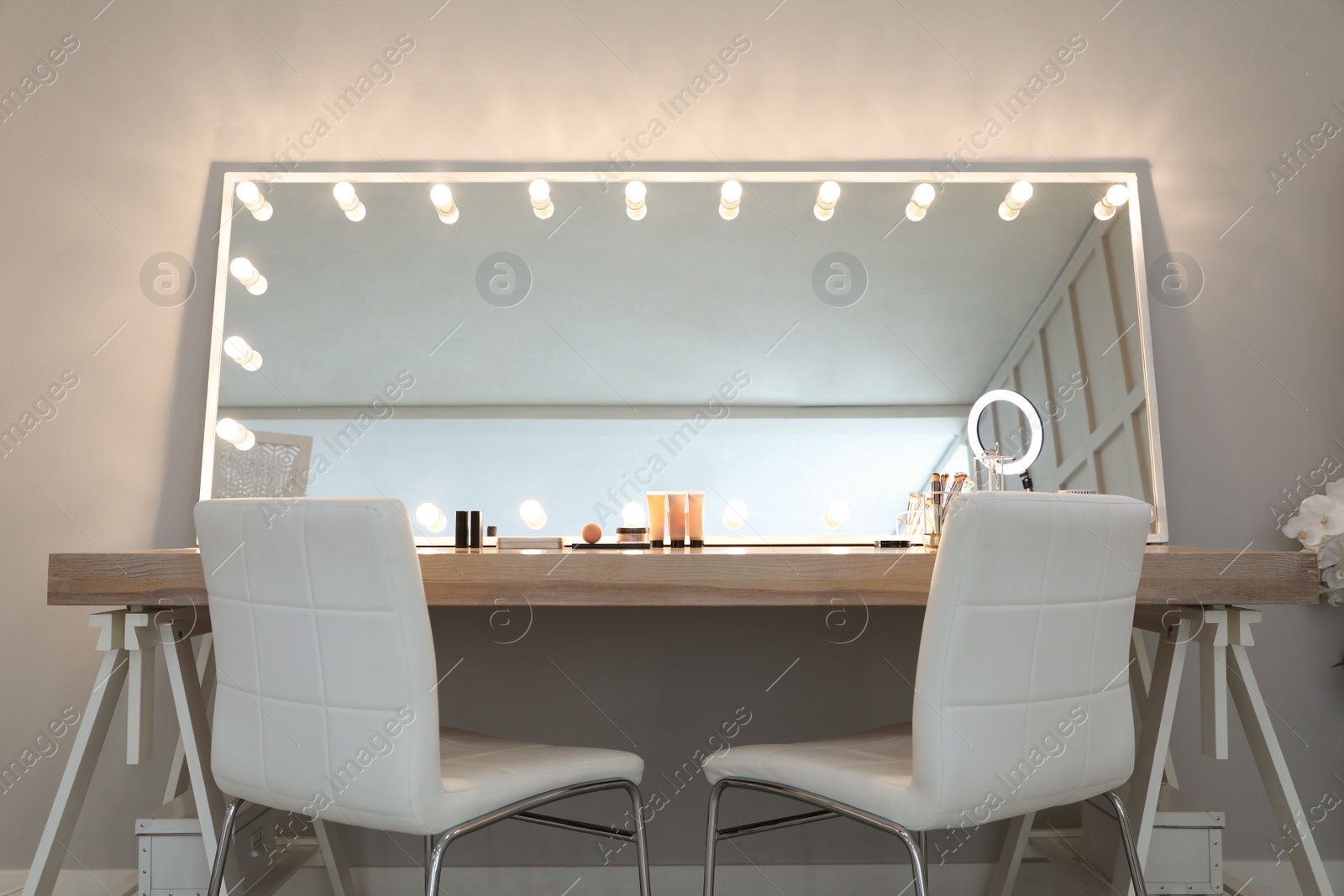 Photo of Modern mirror with light bulbs on dressing table in makeup room