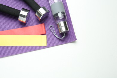 Flat lay composition with fitness elastic bands on white background