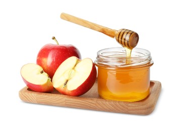 Photo of Pouring tasty honey from dipper into jar and apples on white background