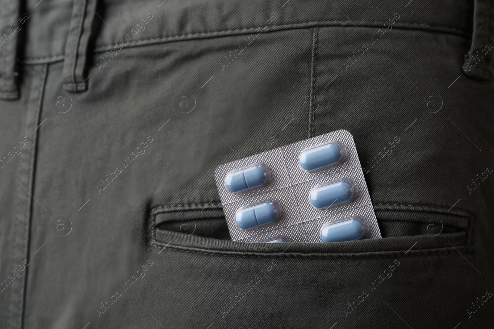 Photo of Jeans with pills in pocket, closeup. Potency problem