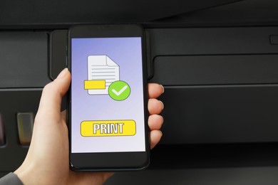 Woman using printer management application on smartphone, closeup and space for text. Image on device screen.