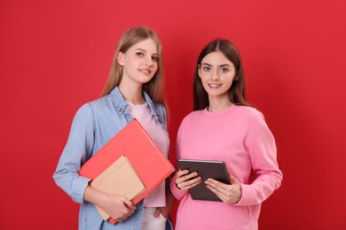 Teenage students with stationery on red background