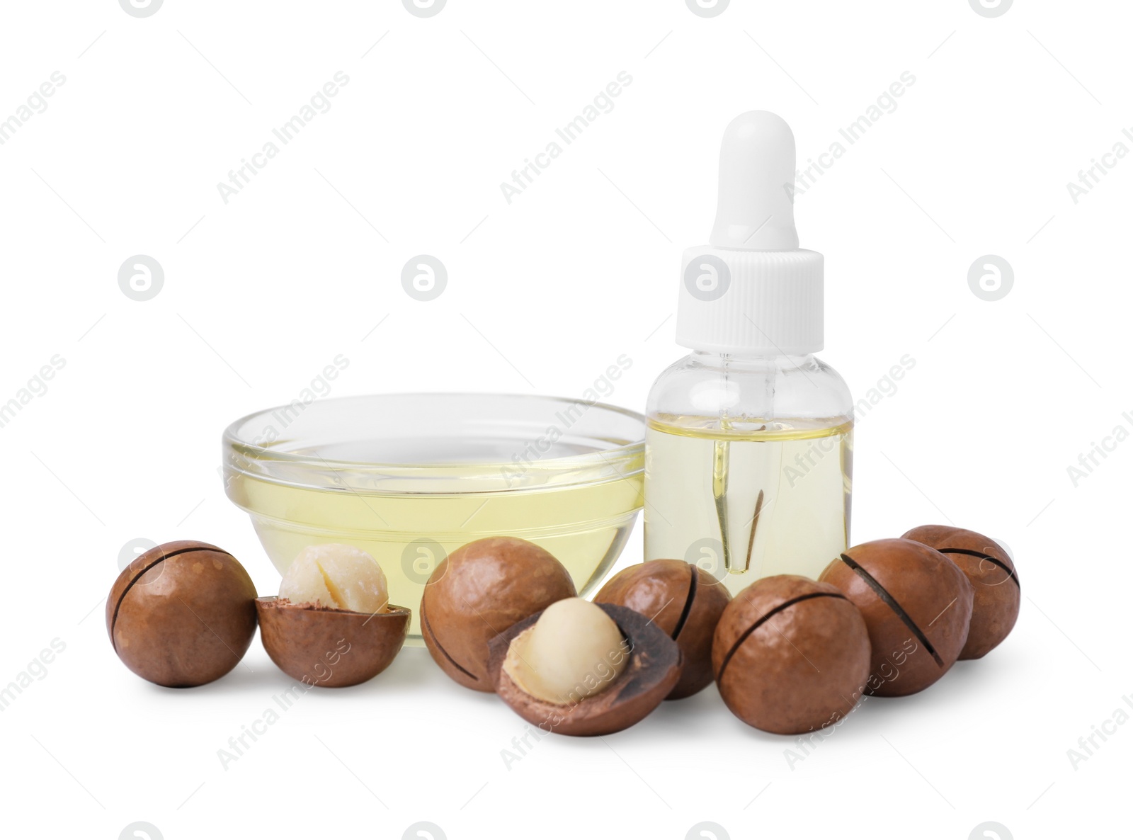 Photo of Delicious organic Macadamia nuts and natural oil isolated on white