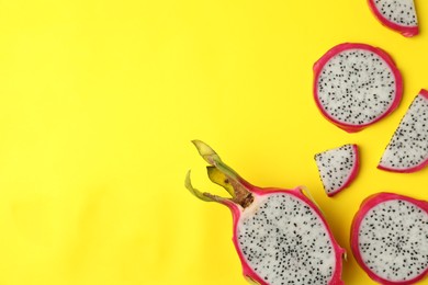 Photo of Delicious cut dragon fruit (pitahaya) on yellow background, flat lay. Space for text