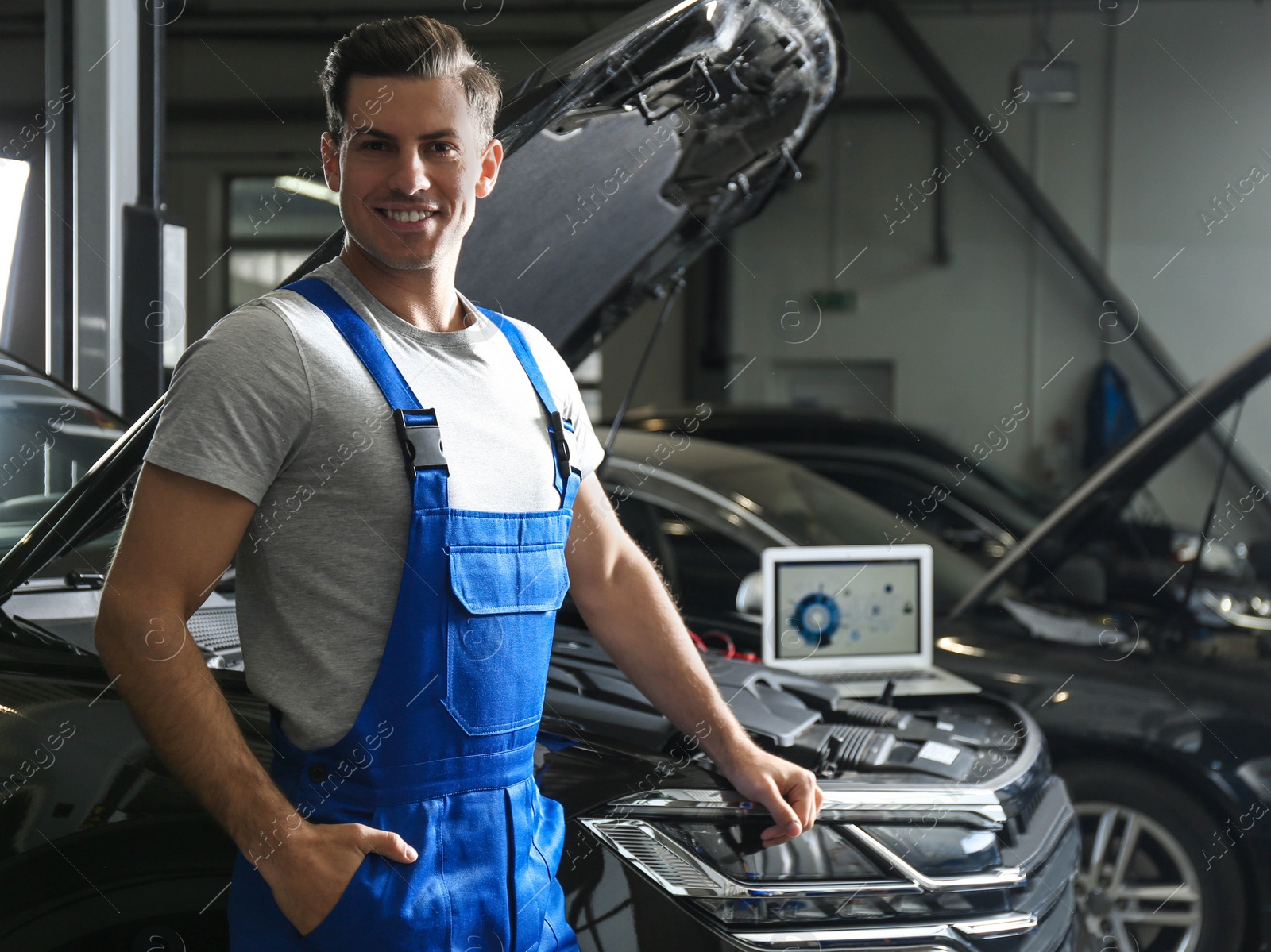 Photo of Mechanic near automobile in service center, space for text. Car diagnostic