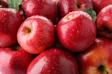 Photo of Many ripe juicy red apples covered with water drops as background