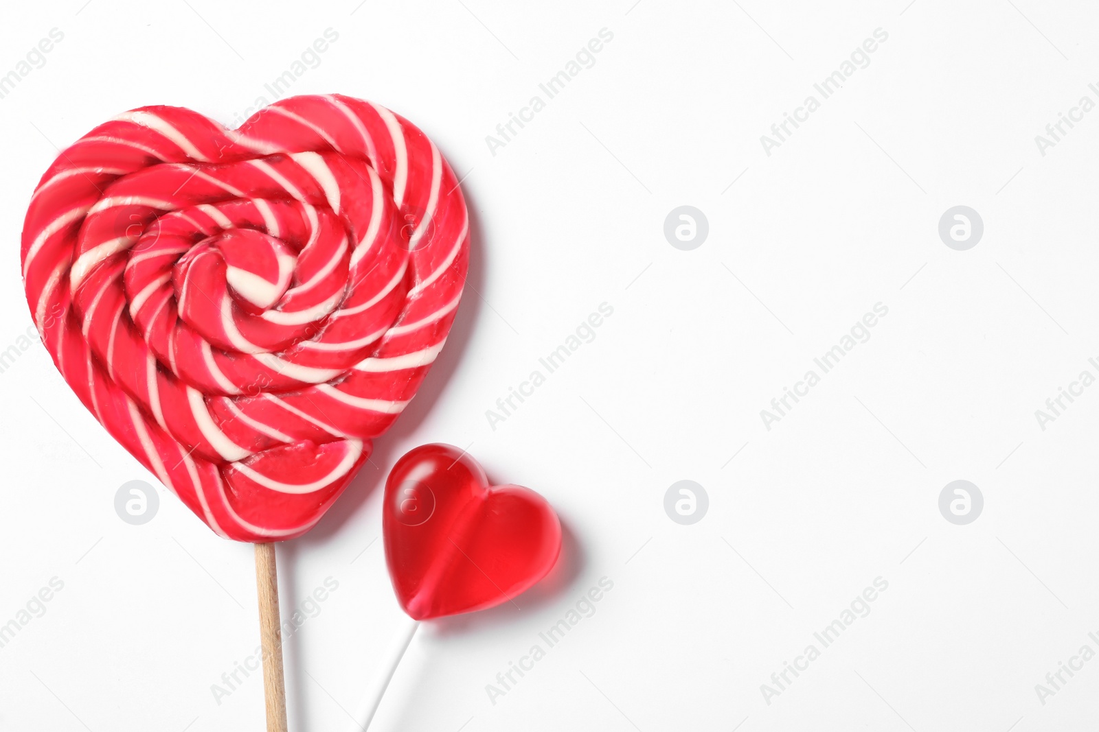 Photo of Sweet heart shaped lollipops on white background, flat lay with space for text. Valentine's day celebration