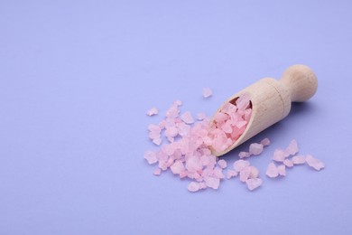 Photo of Scoop with pink sea salt on violet background. Space for text