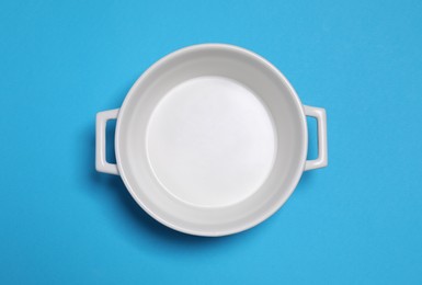 Photo of White empty pot on light blue background, top view