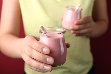 Image of Woman with tasty smoothie on red background, closeup