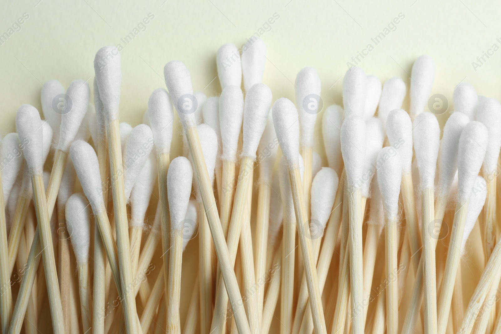 Photo of Heap of cotton buds on beige background, top view