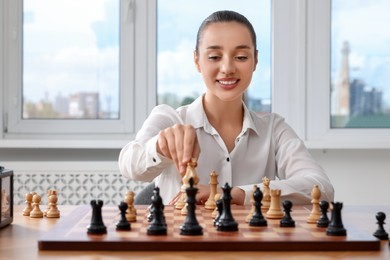 Woman playing chess during tournament at table indoors