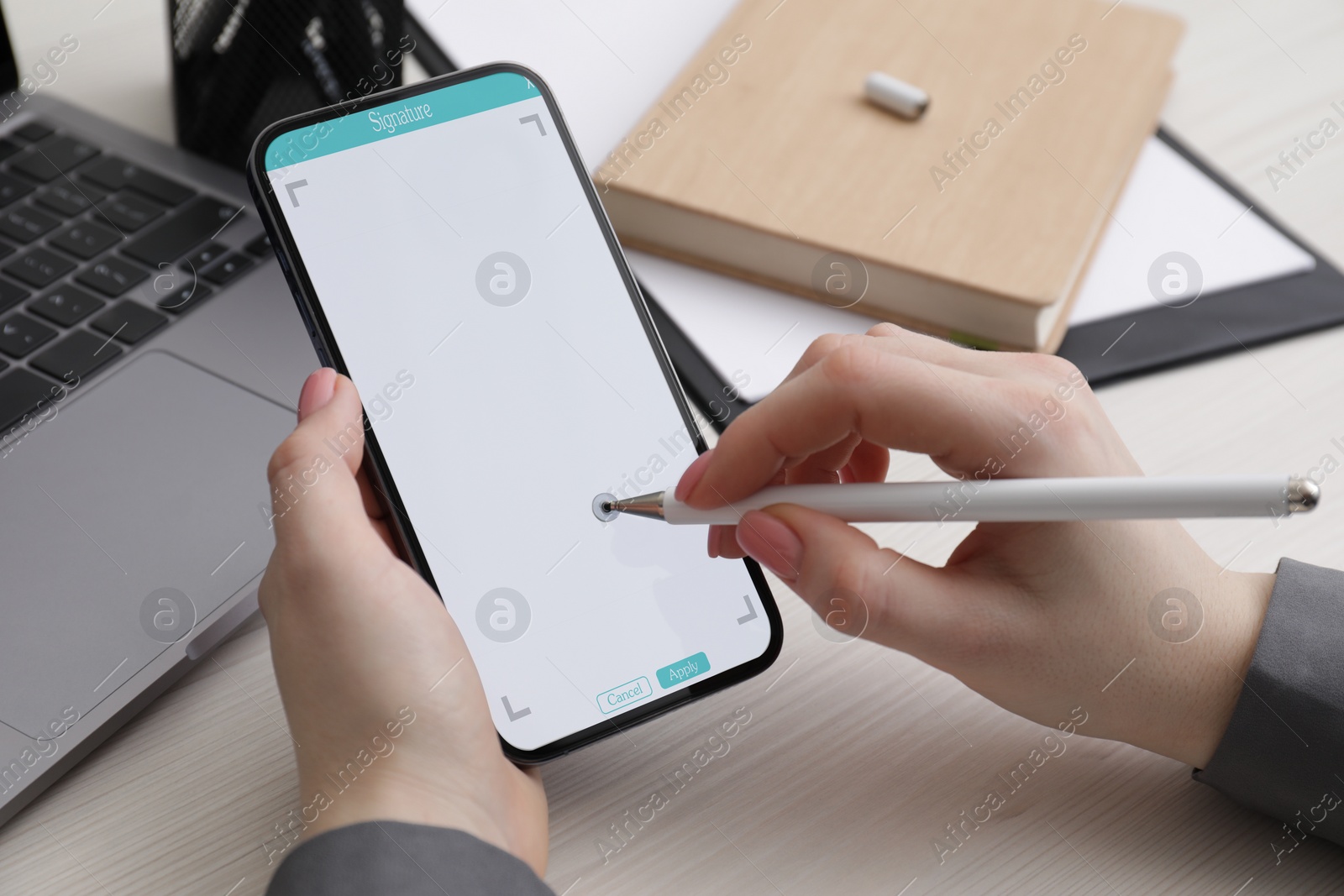 Image of Electronic signature. Woman using stylus and mobile phone at white wooden table, closeup