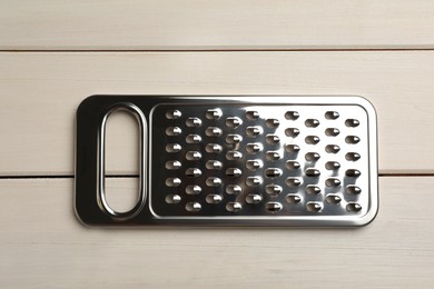 Photo of Modern grater on white wooden table, top view