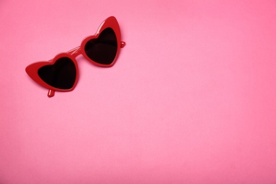 Stylish heart shaped glasses on color background, top view. Space for text