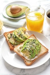 Photo of Toast bread with avocado and glass of juice on table