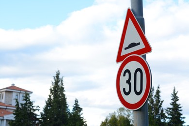 Photo of Post with road signs Maximum Speed 30 and Speed Bump outdoors on sunny day, space for text
