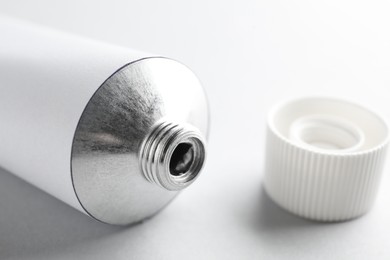Photo of Open ointment tube on white background, closeup