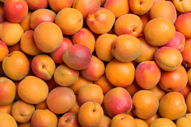 Photo of Delicious fresh ripe apricots as background, top view