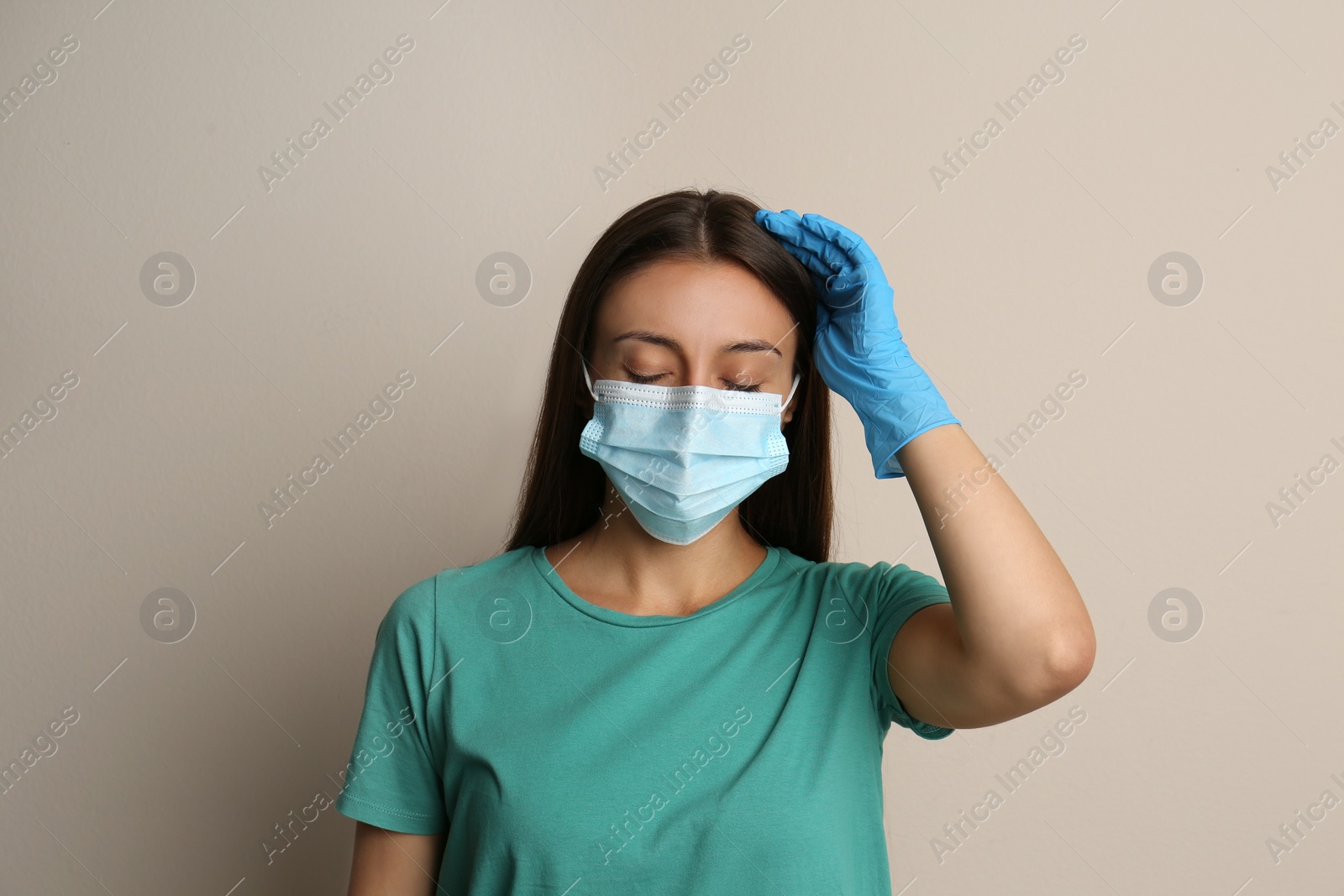 Photo of Stressed woman in protective mask on beige background. Mental health problems during COVID-19 pandemic