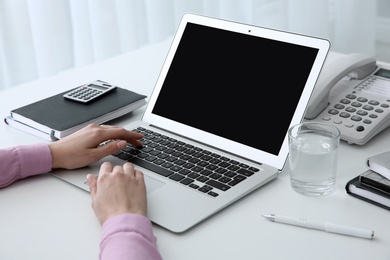 Young woman using modern laptop at table, closeup