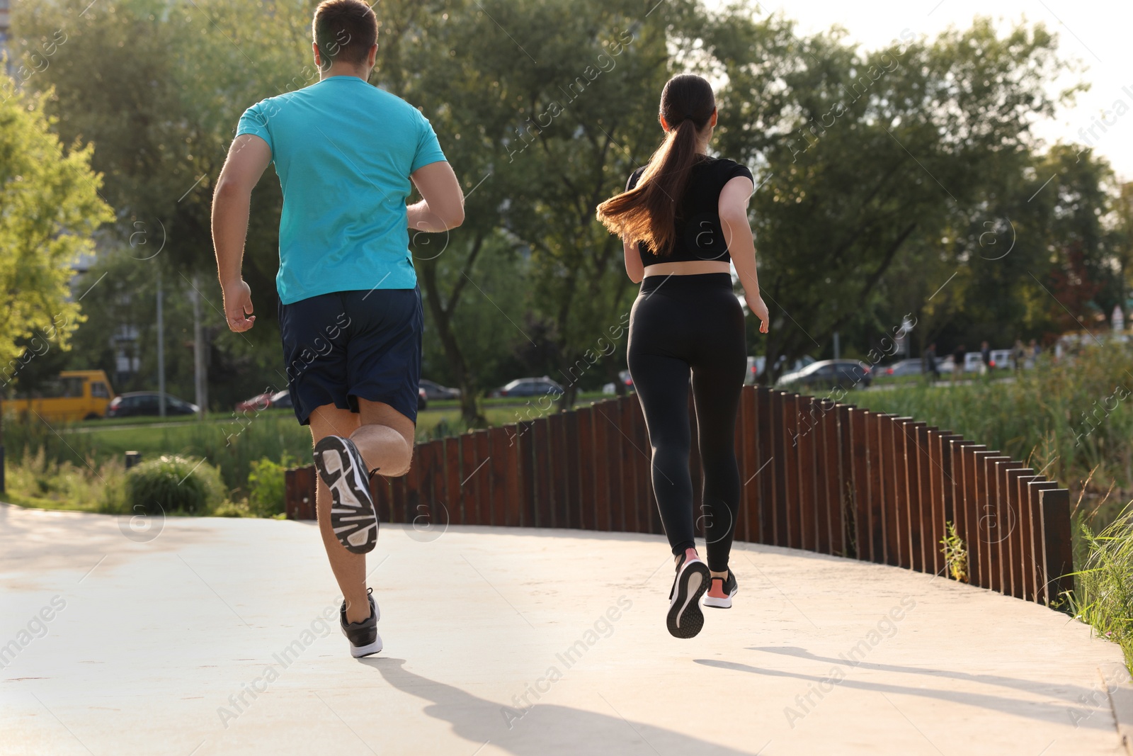 Photo of Healthy lifestyle. Couple running outdoors, back view