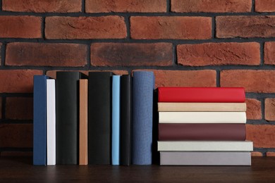 Photo of Many different hardcover books on wooden table