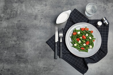 Flat lay composition with plate of fresh green bean salad on table