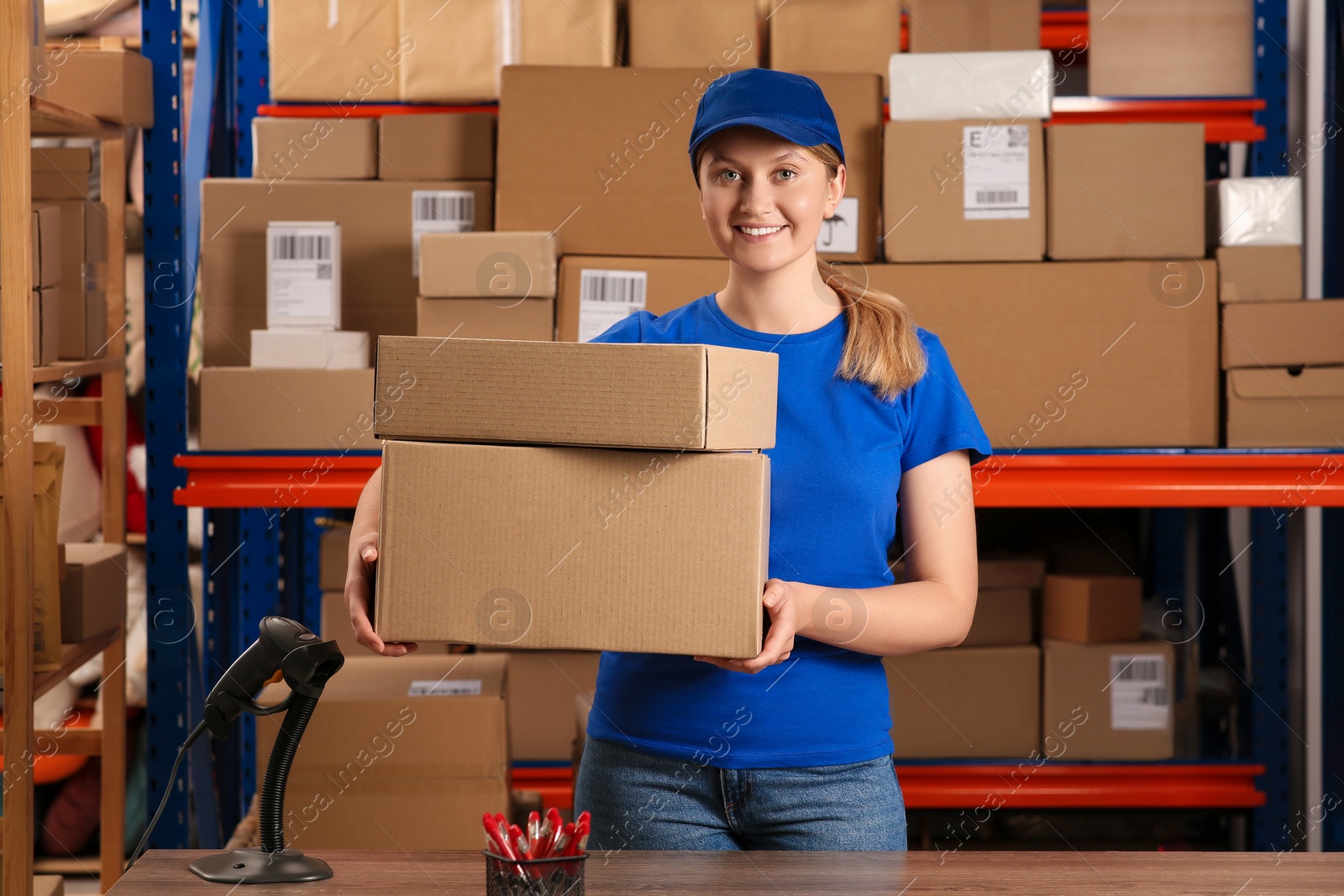 Photo of Post office worker with parcels near rack indoors, space for text