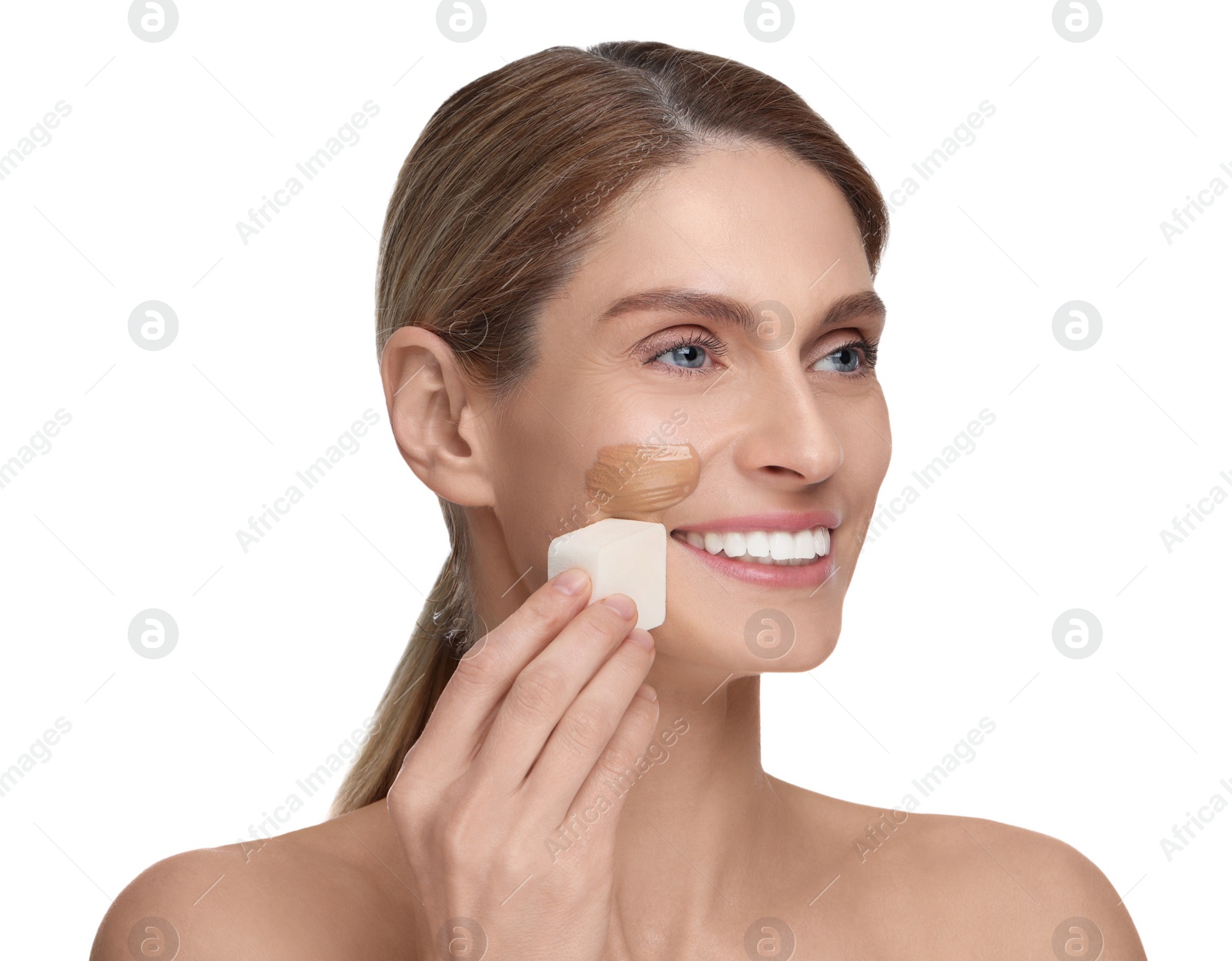 Photo of Woman applying foundation on face with makeup sponge against white background